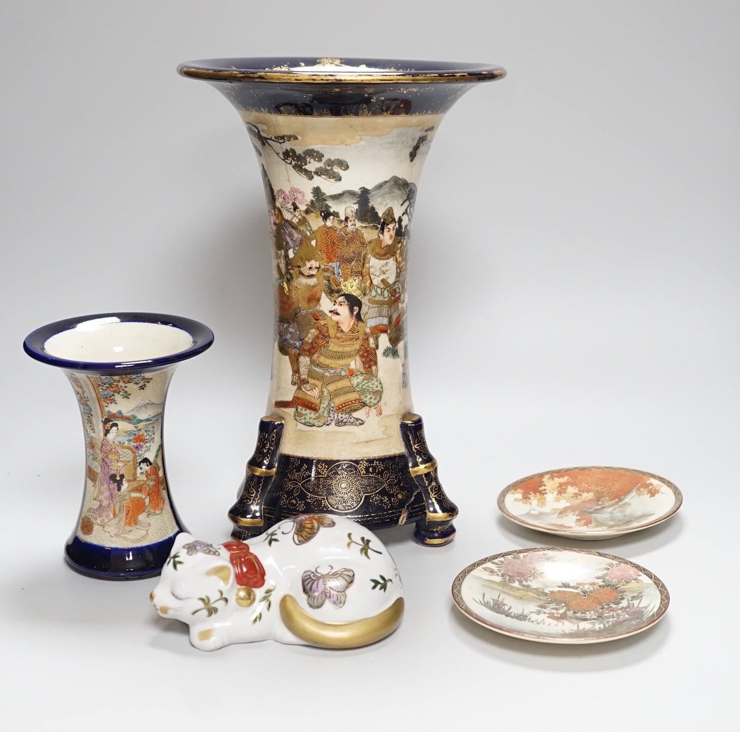 A Japanese Satsuma vase, a smaller vase two saucers and a cat, tallest vase 30cms high